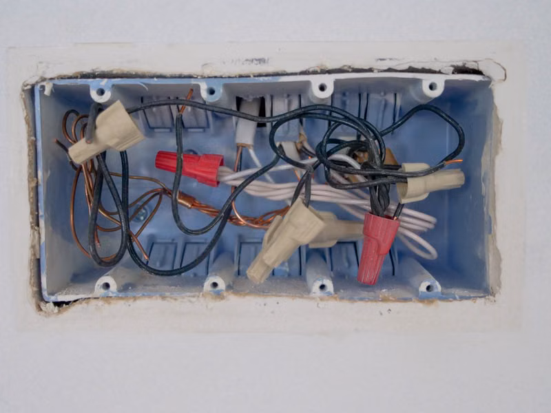 Detailed view of an opened electrical switchboard with visible wires and connectors.